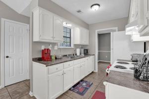 a kitchen with white cabinets and a counter top at Glamorous 3BR 2BA house w/ large fenced backyard in Memphis