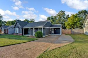 a house with a driveway and a fence at Glamorous 3BR 2BA house w/ large fenced backyard in Memphis