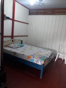 una piccola camera con letto e sedia di Hostal tachiwa a Puerto Nariño