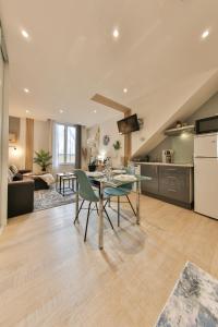 a kitchen and living room with a table and chairs at LES FRANKLINS APPARTEMENTS - Hyper CENTRE Mulhouse in Mulhouse
