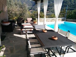 a patio with a table and chairs next to a pool at Il Portico Suite de Charme in Vescina