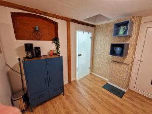 une chambre avec une armoire bleue et une porte dans l'établissement Schönes Apartment in Niebüll, à Niebüll