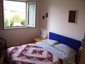 a bedroom with a bed with a quilt on it at Appartamento nel Verde sul Mare di Senigallia in Senigallia