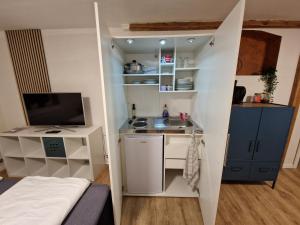 een kleine kamer met een wastafel en een keuken bij Schönes Apartment in Niebüll in Niebüll