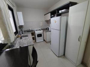 cocina con electrodomésticos blancos y nevera blanca en Independencia 880 Nueva Córdoba 2 hab 2 baños 2 a 5pax en Córdoba