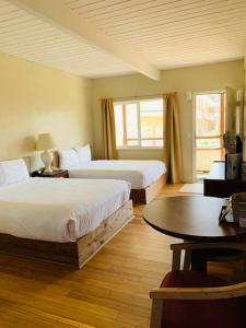 Ocean Shores Inn & Suites في أوشن شورز: غرفة فندقية بسريرين وطاولة