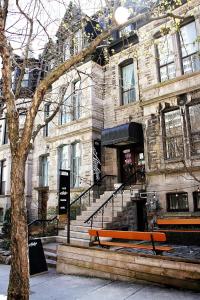 a building with two benches in front of a building at Ambrose House & Cafe - SELF CHECK-IN GUESTHOUSE in Montréal