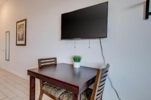 a table with two chairs and a television on a wall at Unit 14 Maui Ohana Modern Studio in Wailuku