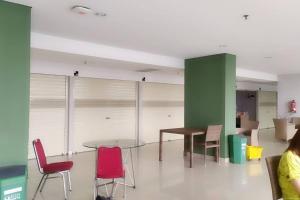a room with red chairs and a table and a green wall at Apartemen M Square 23m2 Jl. Cibaduyut No. 142 in Bandung