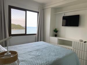 1 dormitorio con cama y ventana grande en Apto Pé na Areia com Linda Vista da Roda Gigante, en Balneário Camboriú