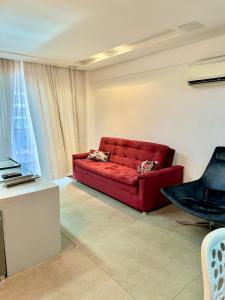 a red couch sitting in a living room at Vip Meireles Beiramar Fortaleza HBM in Fortaleza