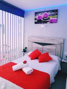 Un dormitorio con una cama roja y blanca con almohadas rojas en AptoVistas al mar-Font de Mar en Cap de Salou en Salou