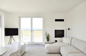 Sala de estar blanca con sofá blanco y chimenea en Backbord - a69059, en Kalifornien