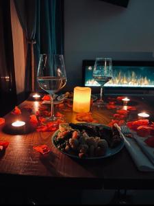 una mesa con un plato de comida y dos copas de vino en Tiny House Retreat Bran, en Bran