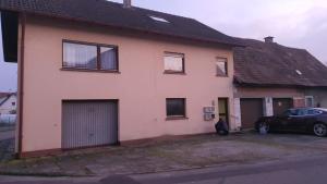 a house with a car parked in front of it at Monteurzimmermit Gemeinschafst Bad-Küche- AM RHEIN 