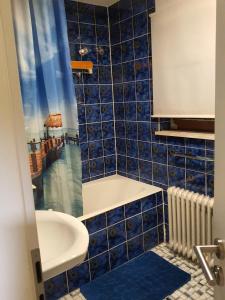 uma casa de banho com paredes em azulejos azuis e um lavatório. em Monteurzimmermit Gemeinschafst Bad-Küche- AM RHEIN 