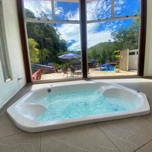 a large bath tub in a room with a window at Hotel Fazenda Bonanza in Engenheiro Paulo de Frontin