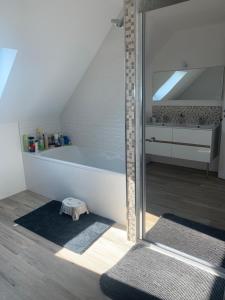 a bathroom with a tub and two rugs on the floor at Maison vue sur mer in Perros-Guirec