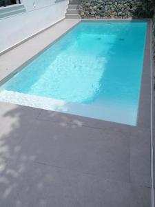 uma piscina com água azul em frente a uma casa em Villa Porto - Βίλα με ιδιωτική πισίνα em Porto Rafti