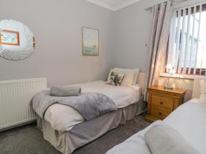 a bedroom with two twin beds and a window at Boathouse in Deganwy