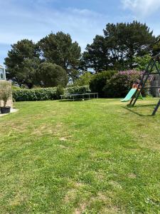 a playground with a slide in the grass at Maison vue sur mer in Perros-Guirec