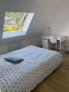 una camera con letto, scrivania e finestra di Maison vue sur mer a Perros-Guirec