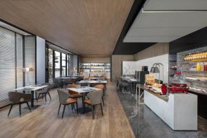 a restaurant with tables and chairs in a room at AC Hotel by Marriott Suzhou China in Suzhou