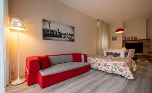 a living room with a red couch and a bed at Lake view with Aircon - 5 minutes from the beach! in Brenzone sul Garda