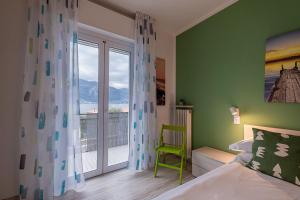 a bedroom with a bed and a balcony with a window at Lake view with Aircon - 5 minutes from the beach! in Brenzone sul Garda