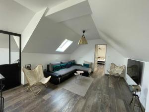 uma sala de estar com um sofá preto e cadeiras em Nuits en Sologne em Romorantin-Lanthenay