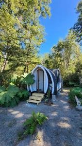 a white tent in a field with trees at Cabañas Los Volcanes Ensenada Puerto Varas in Ensenada