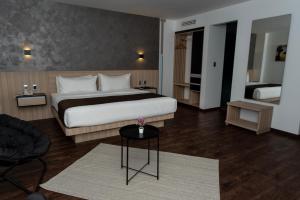 a bedroom with a bed and a table in a room at Fato Hotel in Querétaro