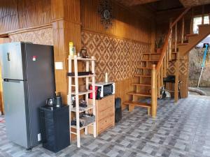 a kitchen with a refrigerator and a staircase in a room at Luxury Bahay Kubo in a Farm Near Tagaytay in Tagaytay