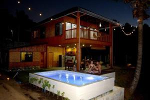 une maison avec une piscine en face de celle-ci dans l'établissement Luxury Bahay Kubo in a Farm Near Tagaytay, à Tagaytay