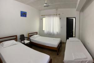 Cette chambre comprend 2 lits et une fenêtre. dans l'établissement Hostal y Camping Villa Guadua Tayrona, à Santa Marta
