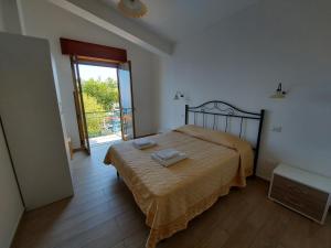 アジェーロラにあるMira Amalfiのベッドルーム1室(ベッド1台付)、スライド式ガラスドアが備わります。