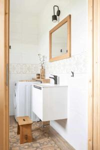 La salle de bains blanche est pourvue d'un lavabo et d'un miroir. dans l'établissement Domki Górski & Polny Kwiat, à Zakopane