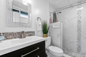 a bathroom with a sink and a toilet and a shower at Unit 17 Maui Ohana Modern Studio in Wailuku