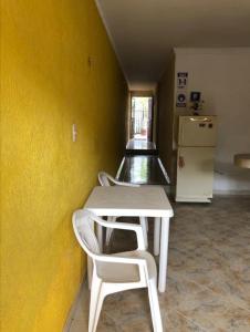 タガンガにあるAlojamiento Casa Tagangaの黄色い壁の部屋(テーブル、椅子付)