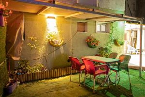 un patio con mesa, sillas y plantas en Dove Suites, en Majdal Shams