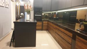 a kitchen with a black counter and wooden cabinets at Aurura PremiumStay Exclusive Home in Johor Bahru