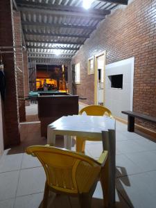 une table et deux chaises dans une pièce avec piano dans l'établissement Casa Moita, Linda Casa, Muito Central, Hospeda até 9 ou 12 Pessoas, à Rio Grande