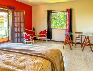 um quarto com uma cama, uma mesa e cadeiras em Incrivel casa com churrasq em Miguel Pereira RJ em Miguel Pereira