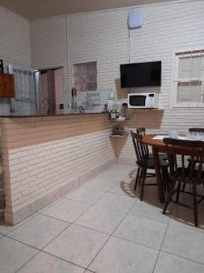 cocina y comedor con mesa y sillas en Casa Moita, Linda Casa, Muito Central, Hospeda até 9 ou 12 Pessoas, en Río Grande