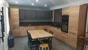 a kitchen with wooden cabinets and a wooden table and chairs at L'esprit de famille in Saint-Parres-lès-Vaudes