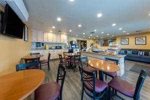 a kitchen and dining room with tables and chairs at Days Inn by Wyndham Lathrop in Lathrop