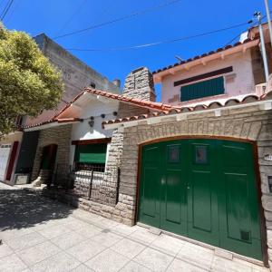 ein Haus mit einer grünen Garage davor in der Unterkunft Chalet Pura Vida in Mar del Plata