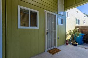 a green house with a door and a window at @ Marbella Lane - Adorable and Quiet Studio in San Mateo
