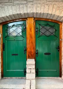 two green doors on a building with at Chalet Pura Vida in Mar del Plata