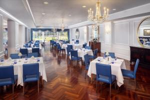 a dining room with tables and chairs and a chandelier at Historic Boone Tavern in Berea